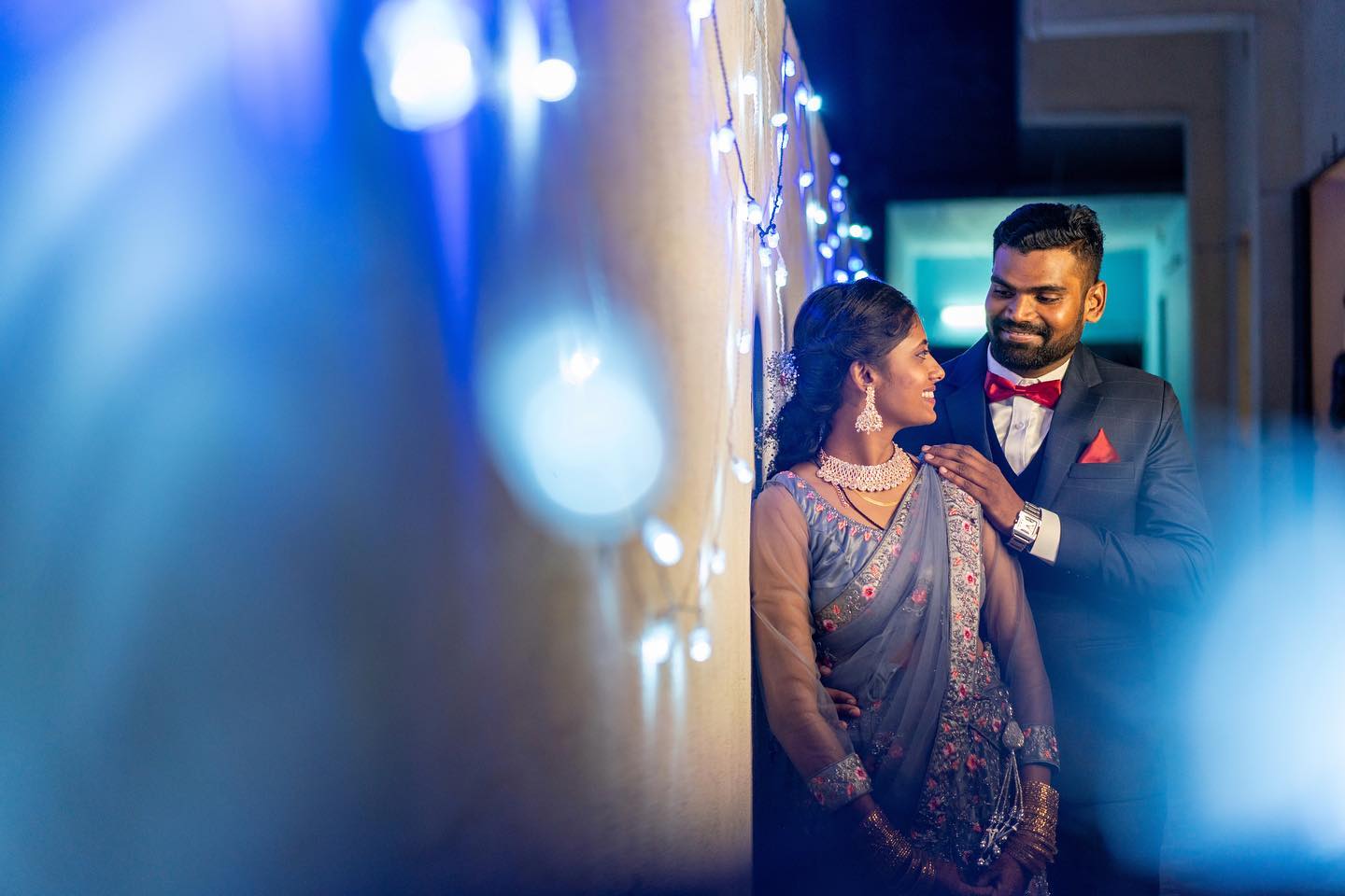 Muthu Pandi and Sujitha reception portrait lit by fairy lights, captured by Wandering Kite Photography